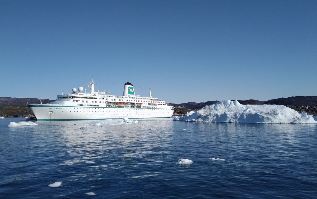 Kreuzfahrtschiff in arktischer Landschaft mit Eisbergen